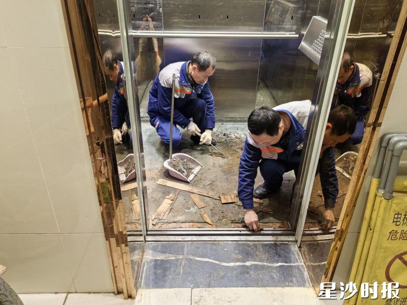 物业服务人员维护电梯。
