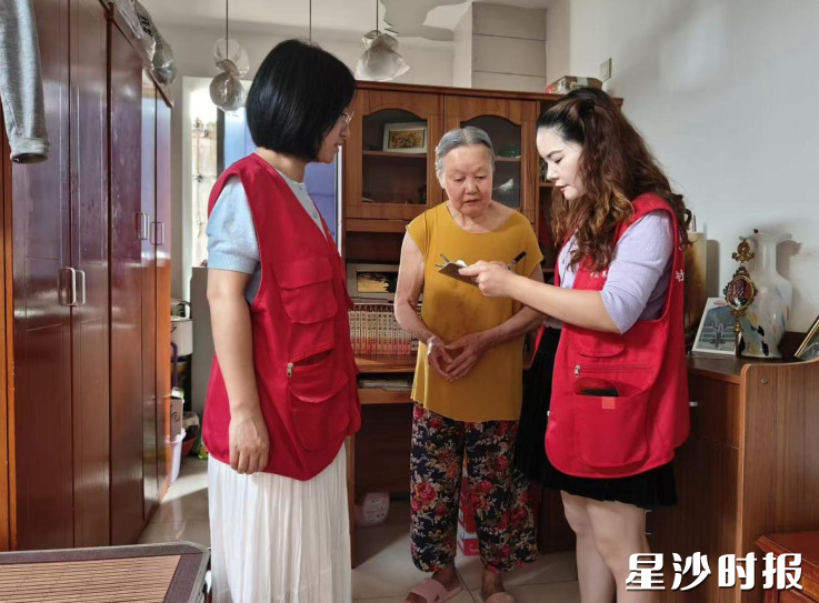 社区网格员上门协助独居老人进行认证工作。 社区网格员上门协助独居老人进行认证工作。