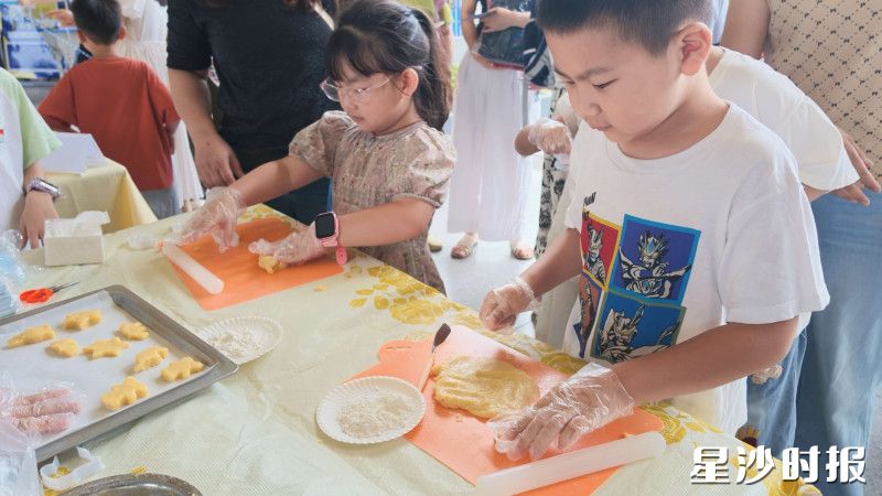 麓山国际松湖小学设置手工烘焙体验区，孩子们戴着手套擀面团、做造型，亲手制作创意饼干，感受动手乐趣。