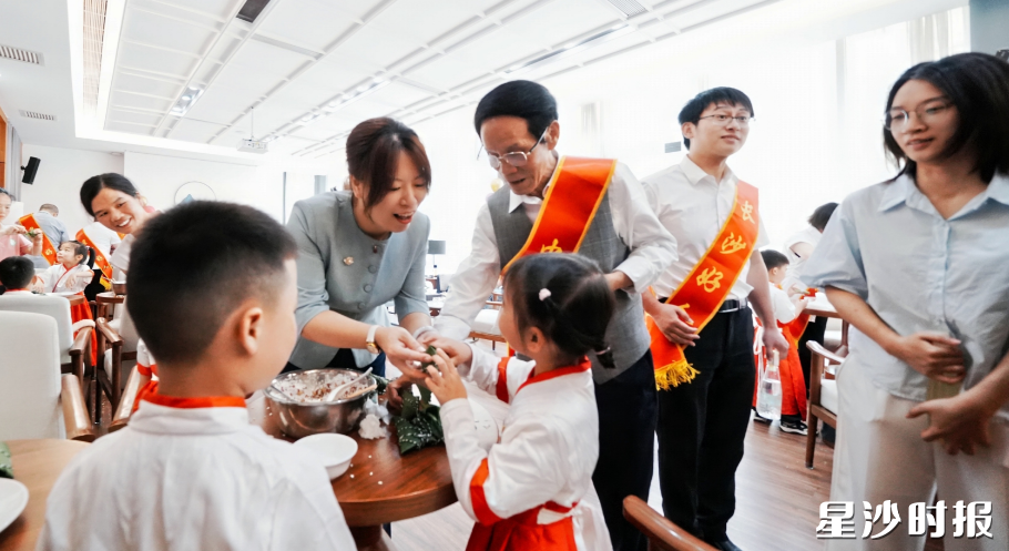 郑曦同中国好人朱有志和小朋友们体验传统包粽子。