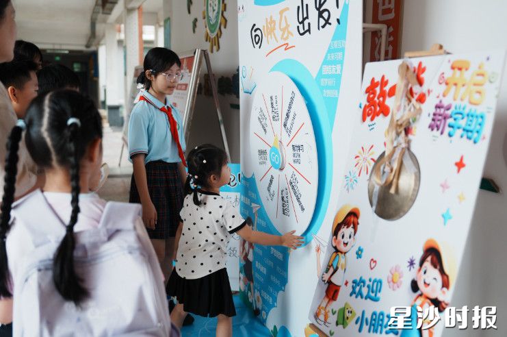 长沙市花园小学设置趣味转盘打卡点，小朋友伸手转动幸运转盘，在互动游戏中收获开学的欢乐。