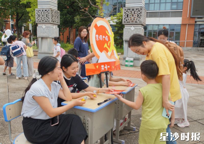 在长沙市自贸实验学校，师生与家长温情互动，孩子接过任务卡片，在游戏体验中迎接新学期。